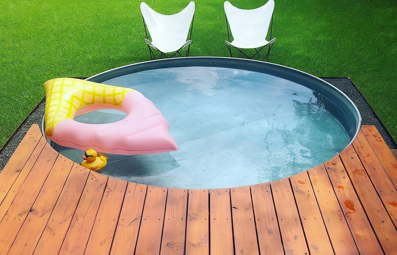 A small round stock tank pool in a grassy garden with two white chairs, a pink float, and a rubber duck on the water.
