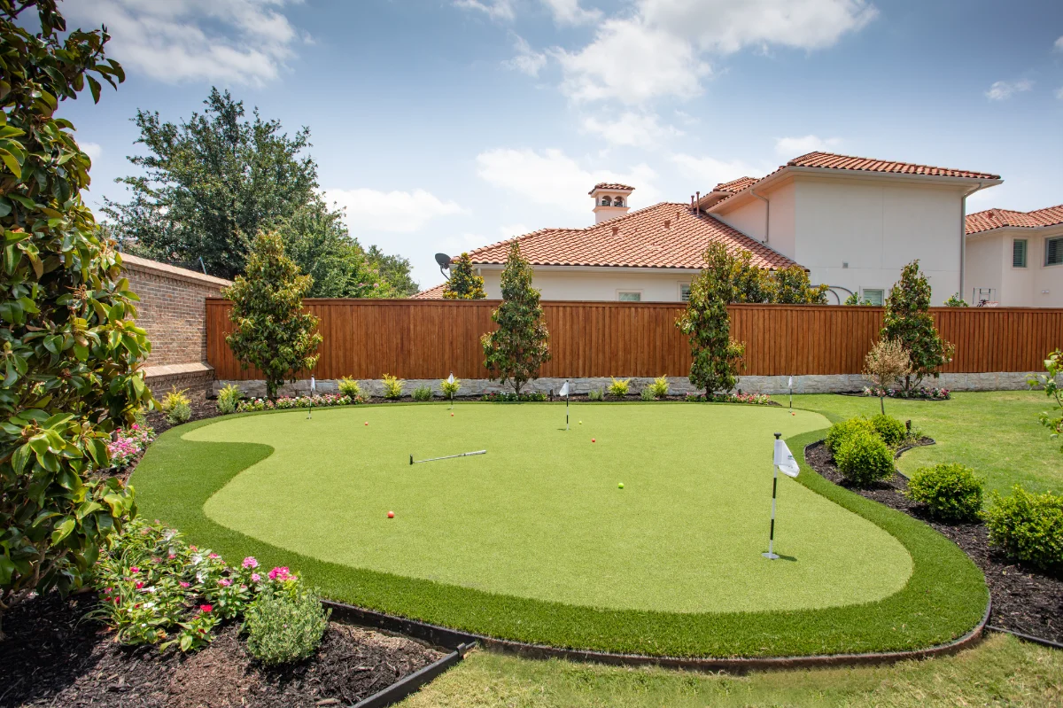 Putting Green in Jacksonville in a backyard with flower beds