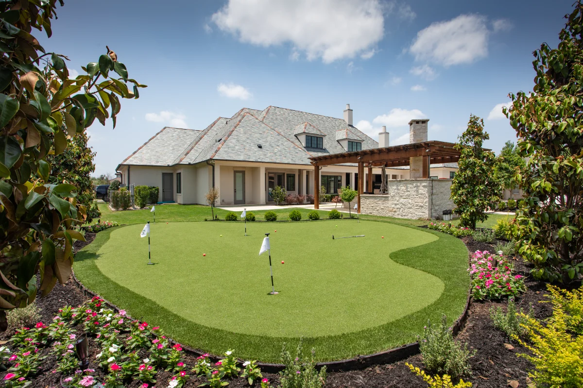 Synthetic Grass Putting Green with flower beds in a residential backyard