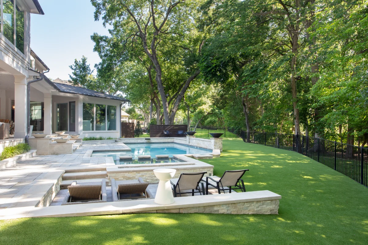 Artificial Turf Backyard in Jacksonville with a pool and travertine patio