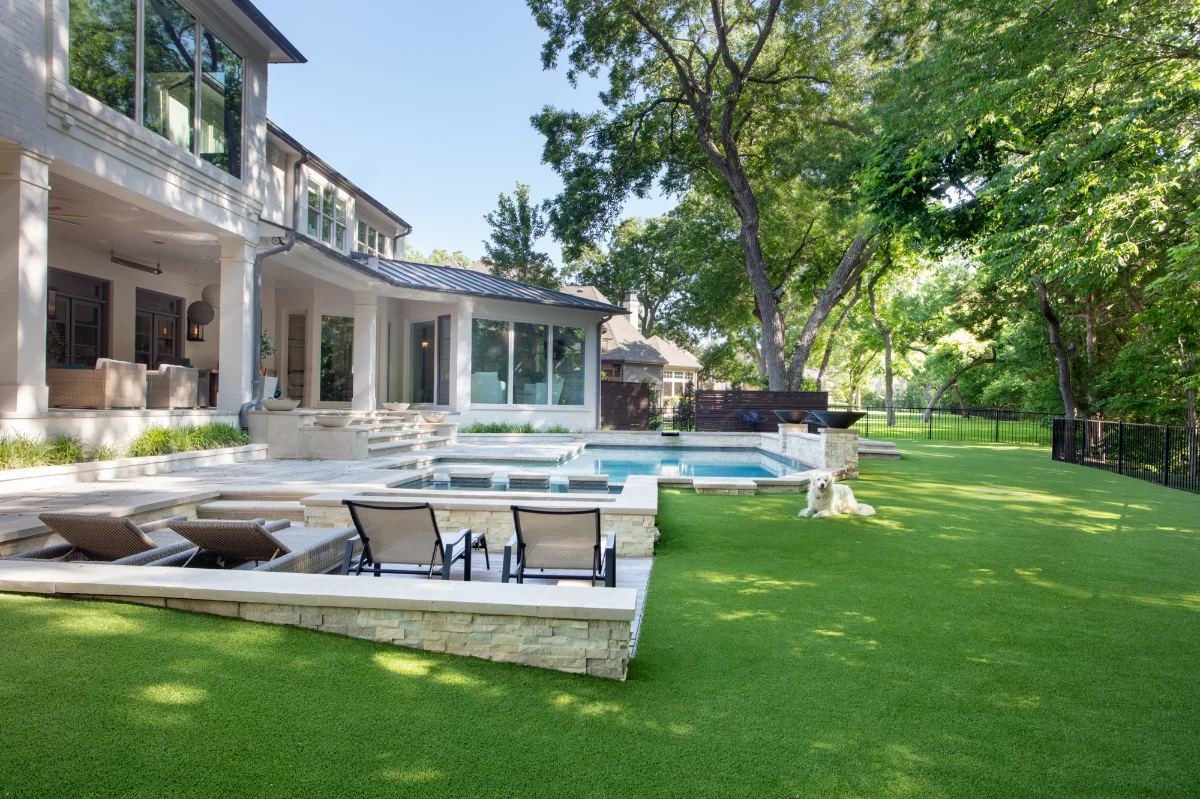 Artificial Grass Yard in Atlanta Artificial Grass Yard in Atlanta with a pool on hilly terrain and a happy dog